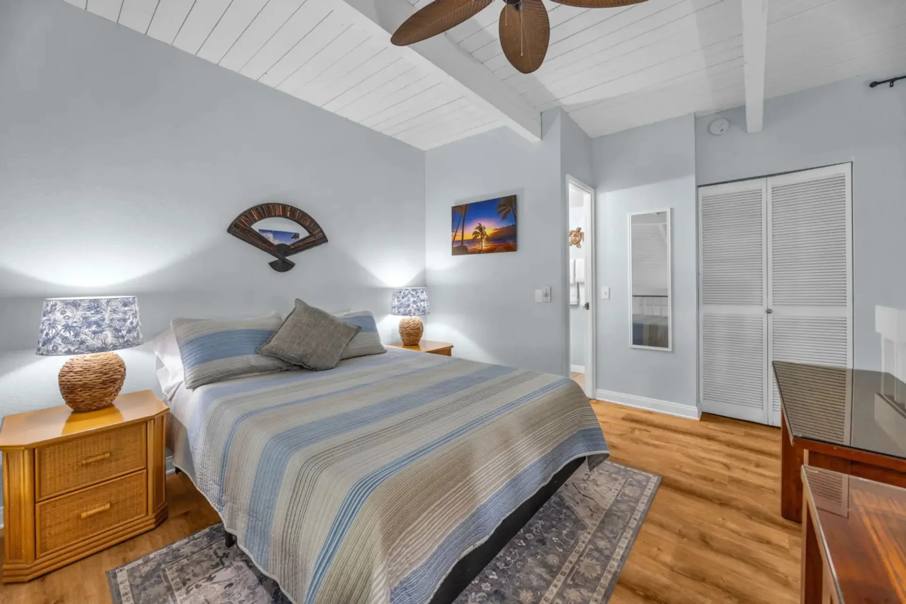 A bedroom with a bed, bedside tables, and a closet.