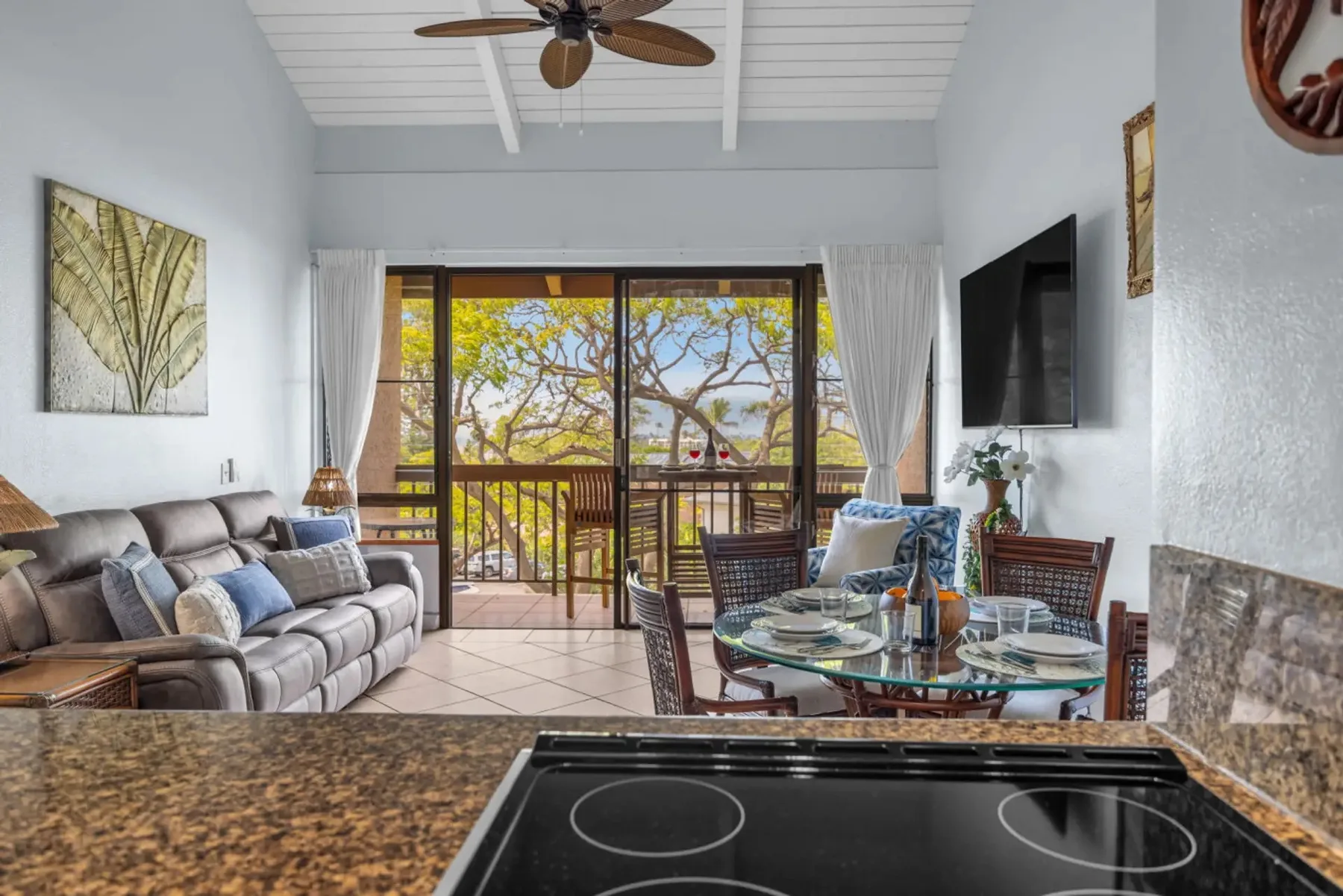 A bright living and dining area opens onto a balcony through sliding glass doors.