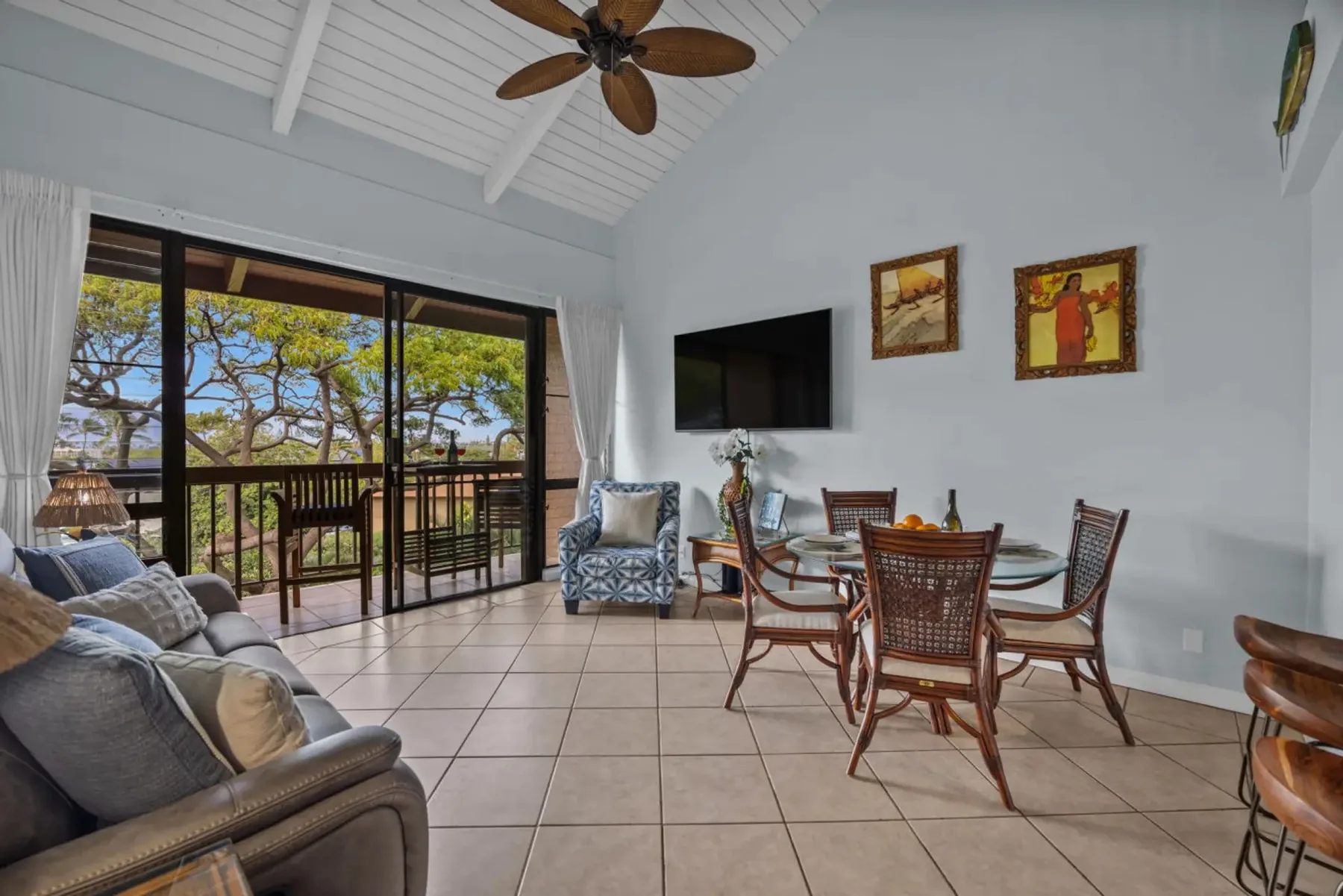 A bright living and dining area opens onto a balcony through large glass doors.