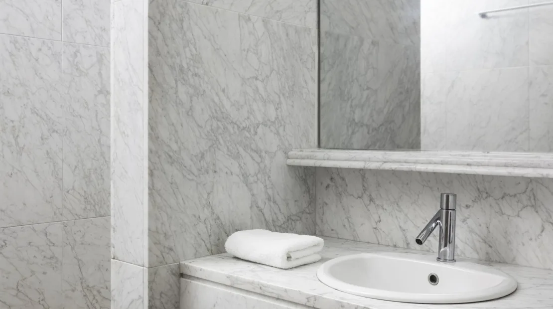 A marble bathroom vanity with a sink and folded towels.
