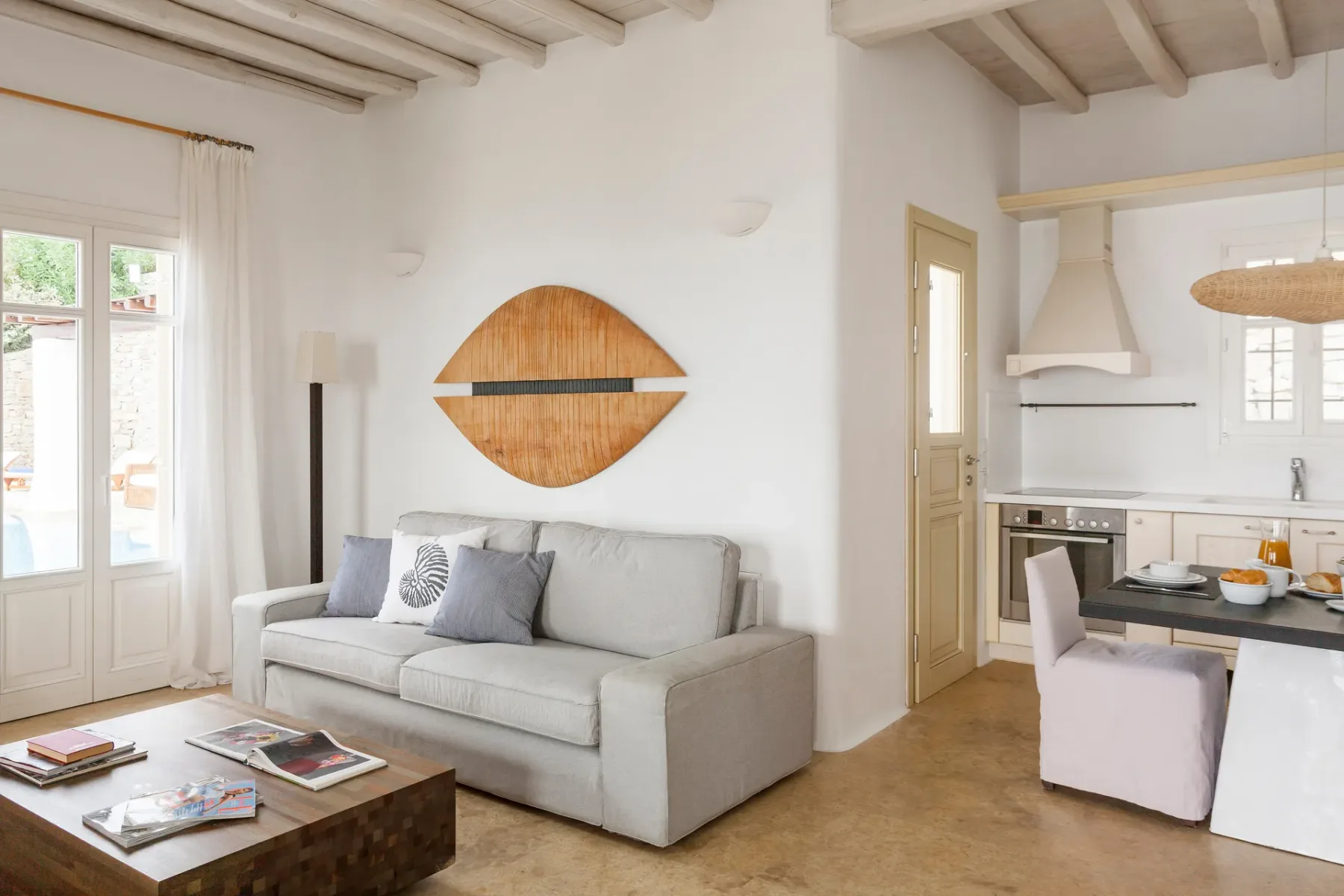 A bright living area with a sofa and an open kitchen.