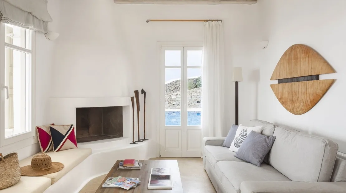 A bright living room with a white sofa and fireplace.
