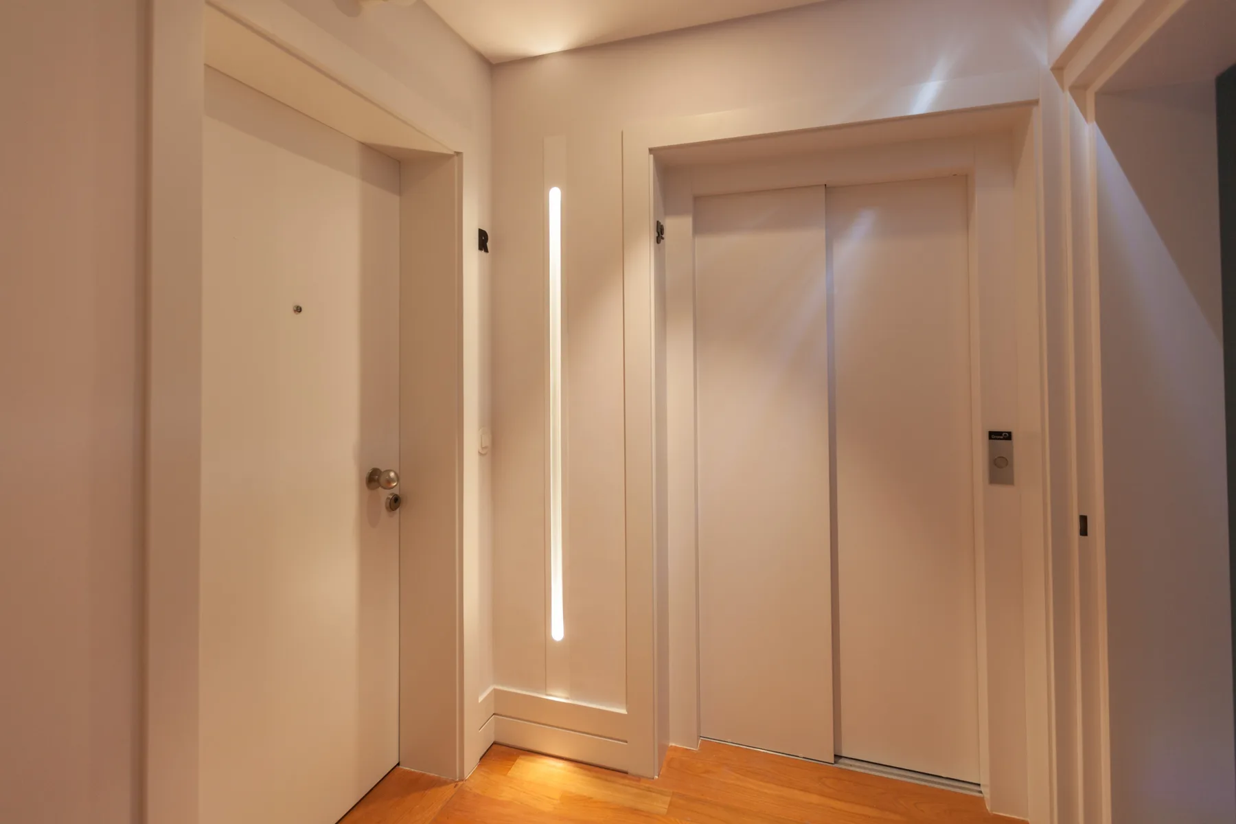 A warm-toned apartment entryway with a closed elevator.