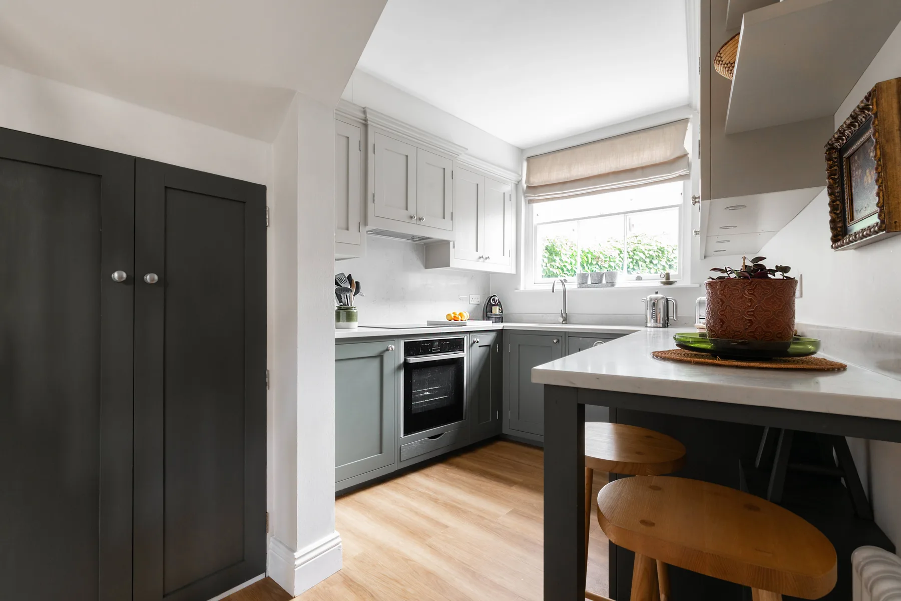A bright kitchen with white cabinets, dark lower cabinets, and a central island.