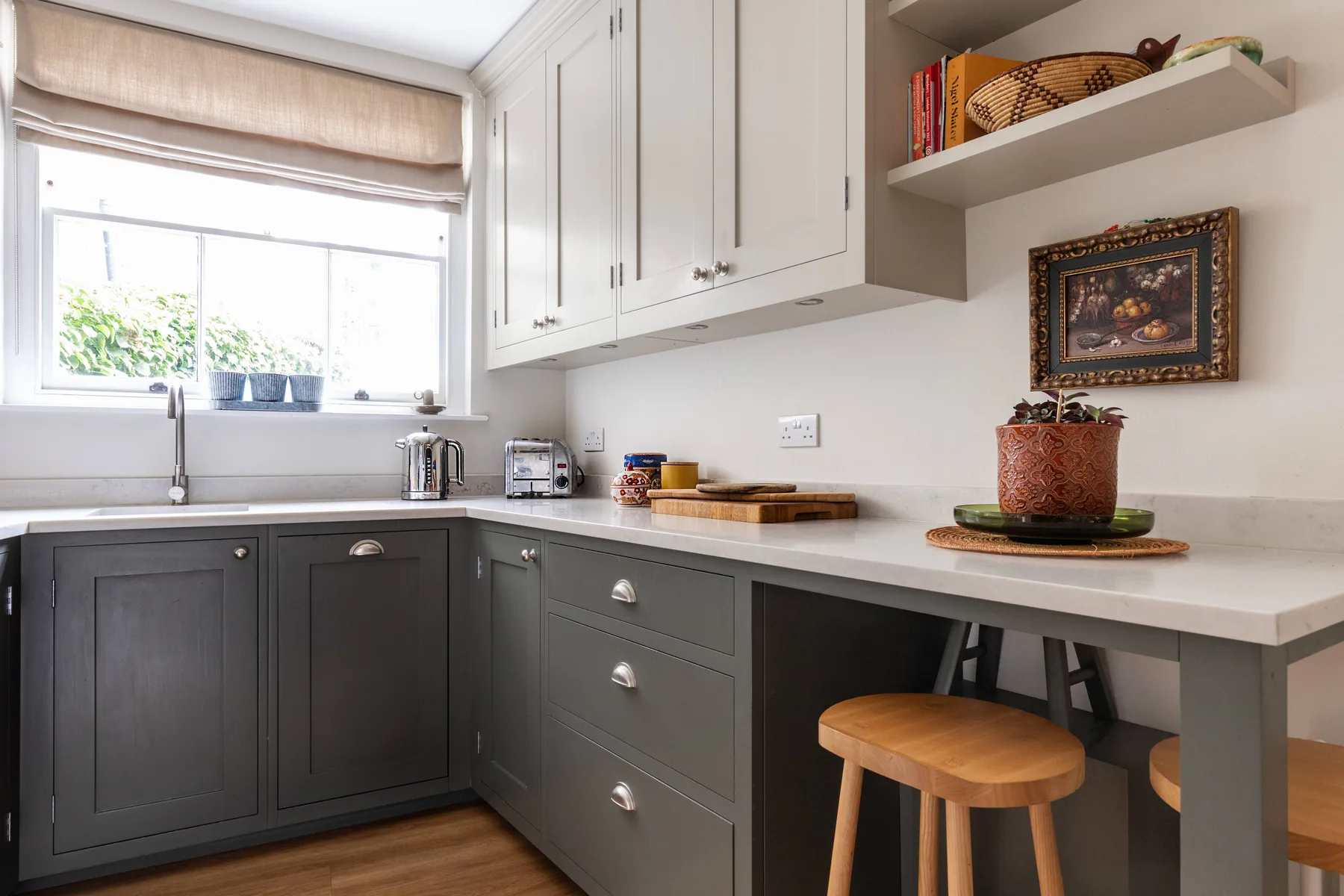 A bright kitchen with dark lower cabinets, a window, and a countertop.