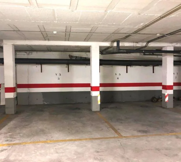 An indoor parking garage with marked spaces and painted stripes on the walls.