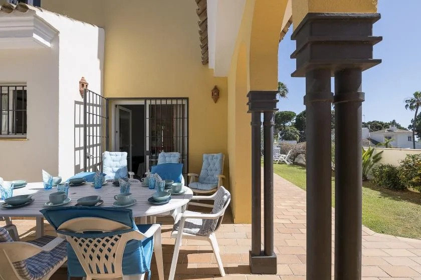 A patio dining area with a table and seating beside an open doorway.