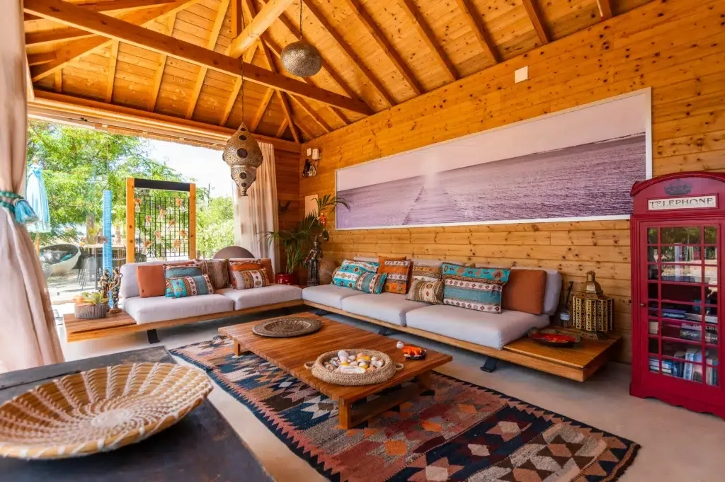 Indoor lounge with exposed wooden beams and colorful seating.