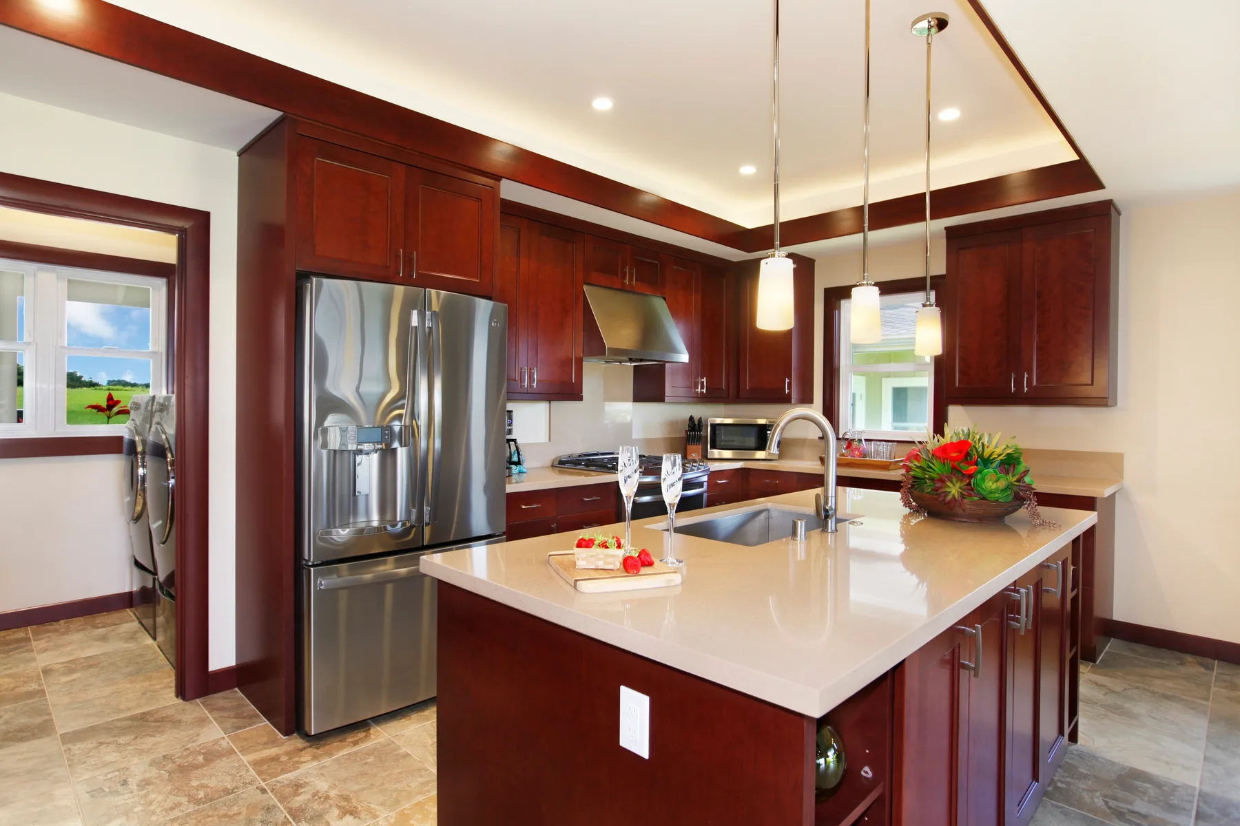 A kitchen with dark wood cabinets, stainless steel appliances, and a large island.