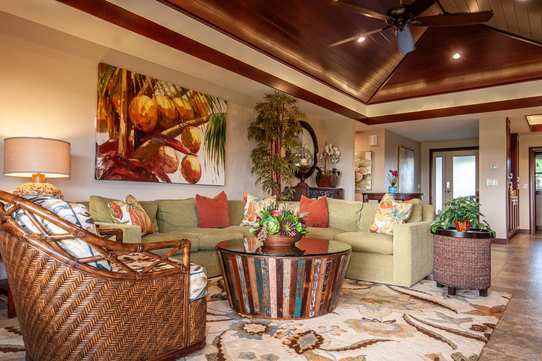 A living room with cushioned seating, a coffee table, and colorful wall art.