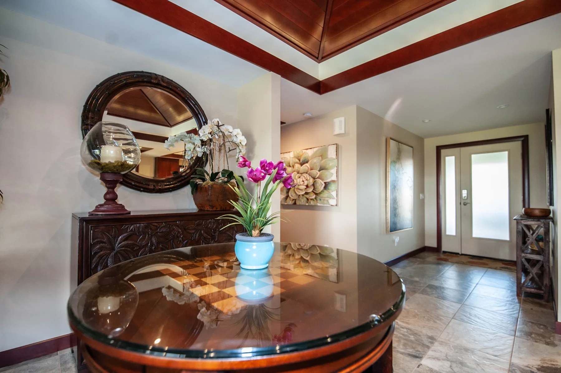 An entryway with a round glass-topped table and a front door.