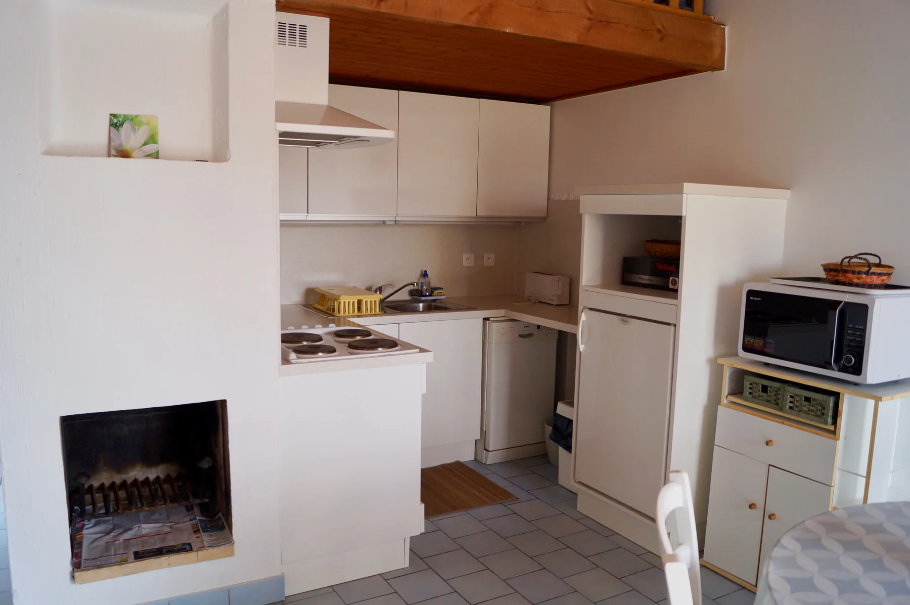 A compact kitchen with white cabinets and a tiled floor.