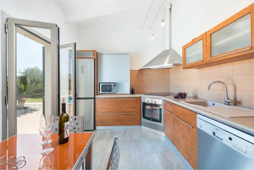 Una cocina luminosa con gabinetes de madera, una encimera y un horno empotrado.
