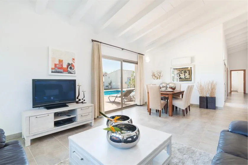 Una luminosa sala y comedor se abre a un patio con piscina.