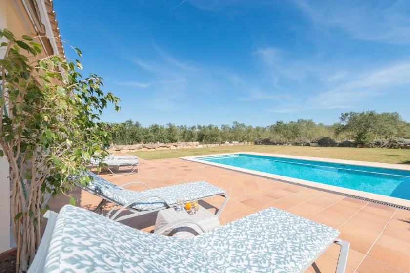 Una zona de piscina al aire libre con asientos estampados en un patio embaldosado.