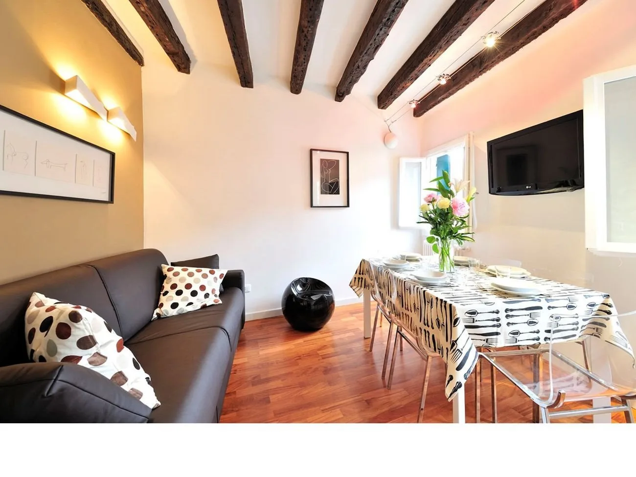 A bright dining and sitting area with a set table and seating.