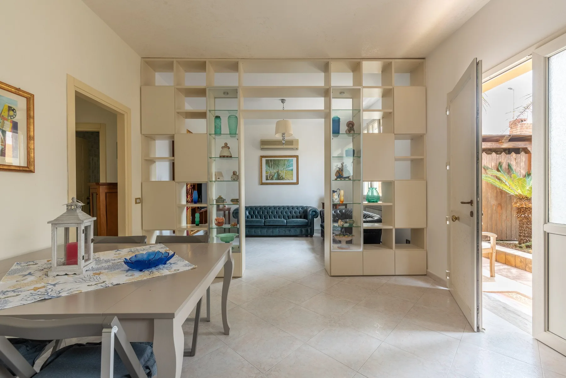 A living room with open shelving and a seating area.