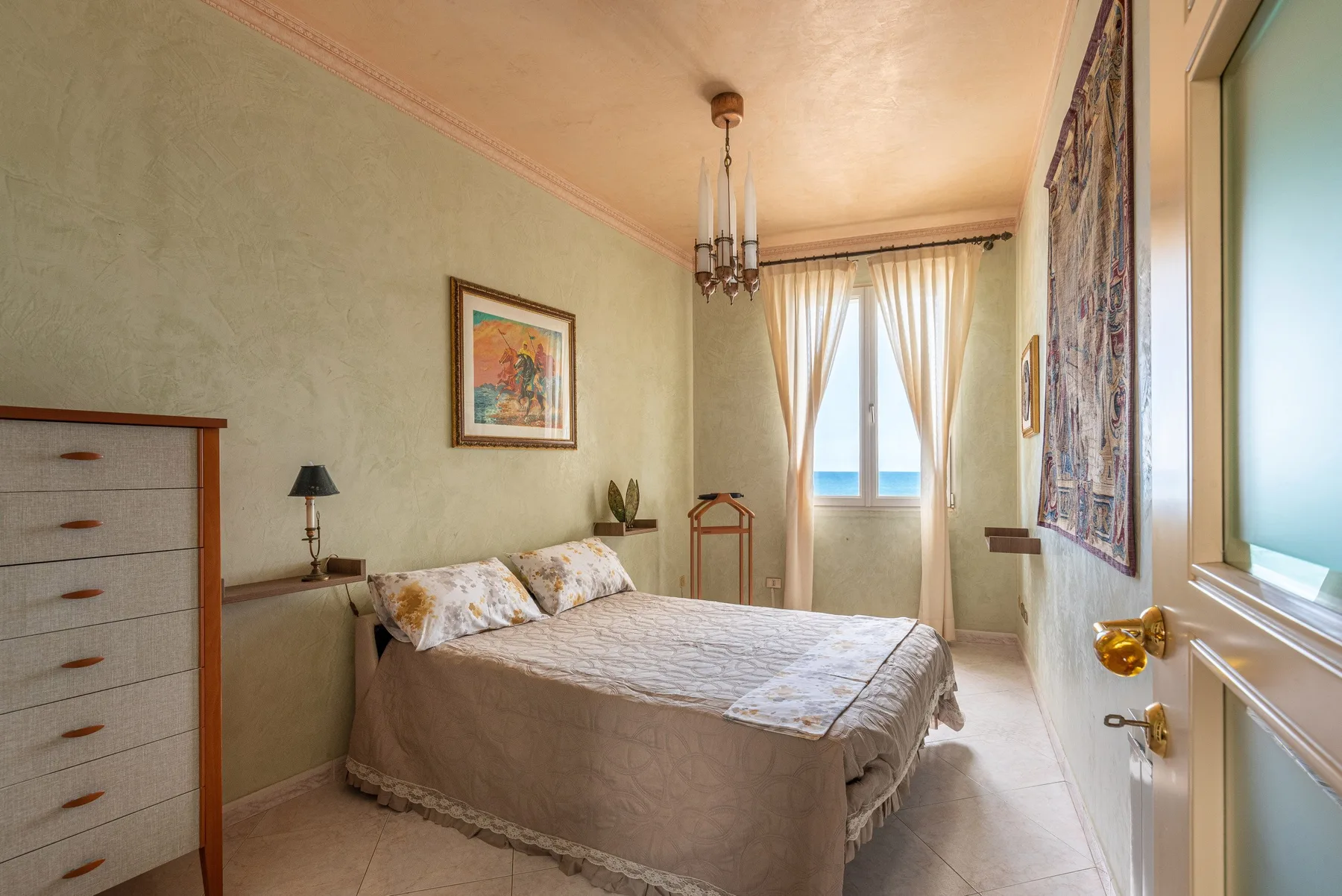 Un dormitorio con una cama, una cómoda y una ventana con cortinas.