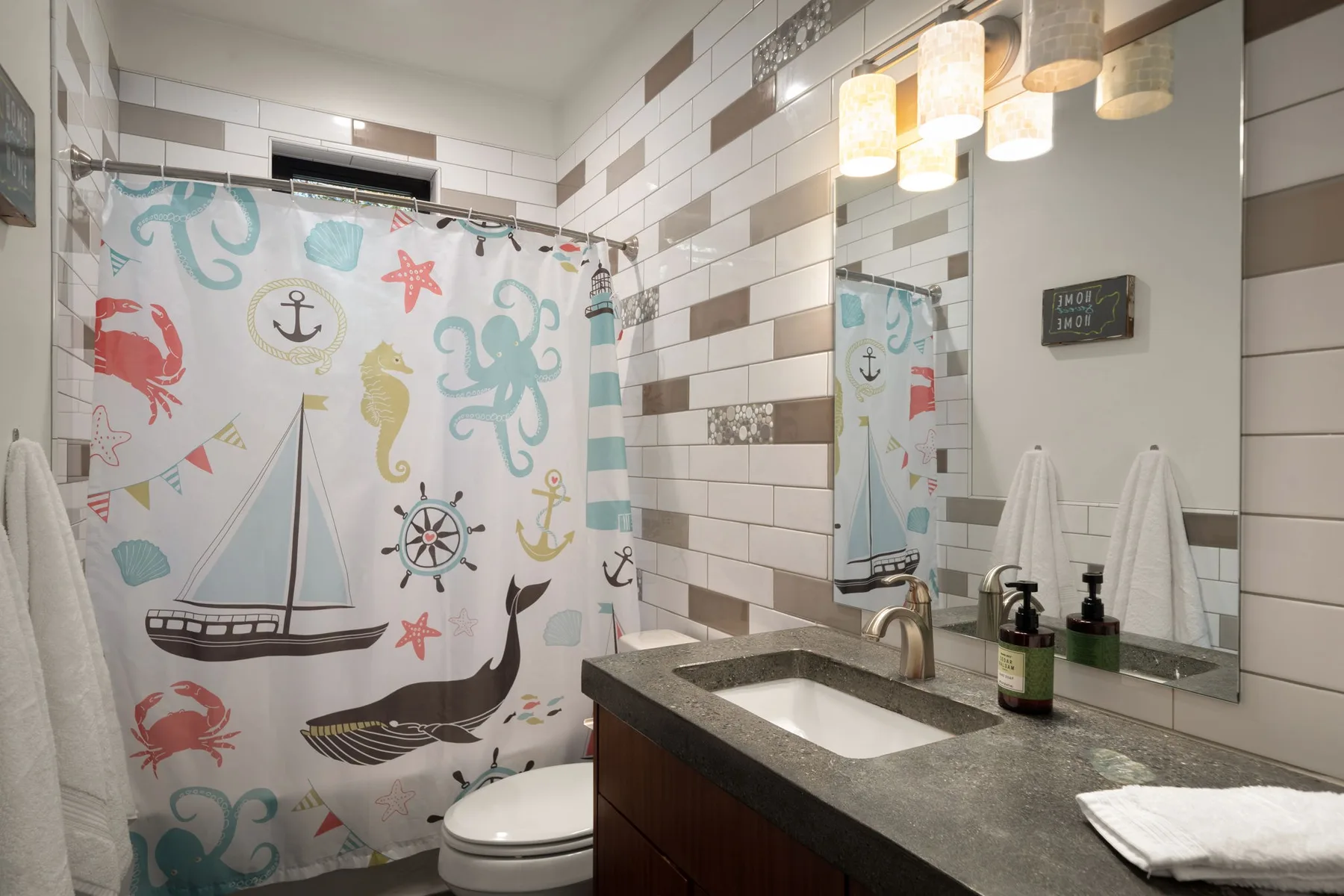 Un baño con una cortina de ducha colorida y un lavabo con mueble.