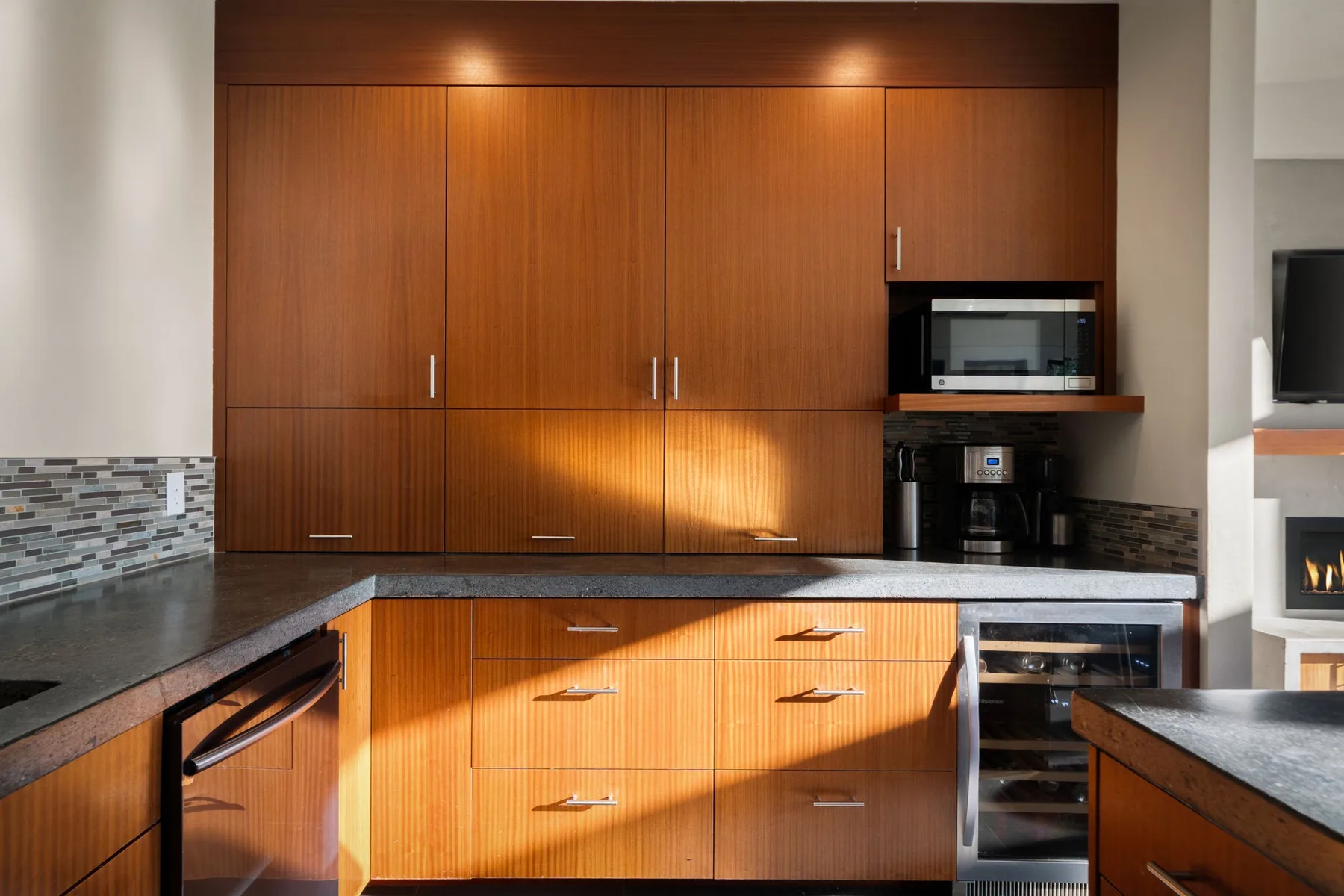 Una cocina moderna con gabinetes de madera y una encimera oscura.