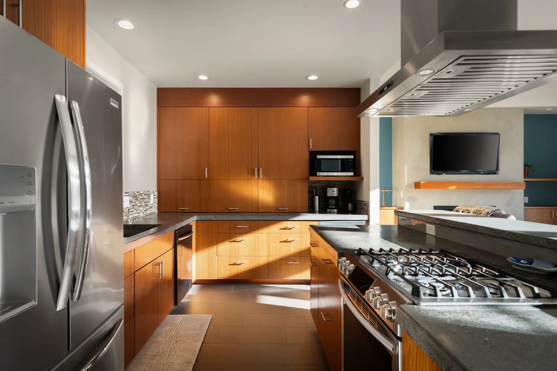 Una cocina moderna con gabinetes de madera, electrodomésticos de acero inoxidable y una amplia estufa.
