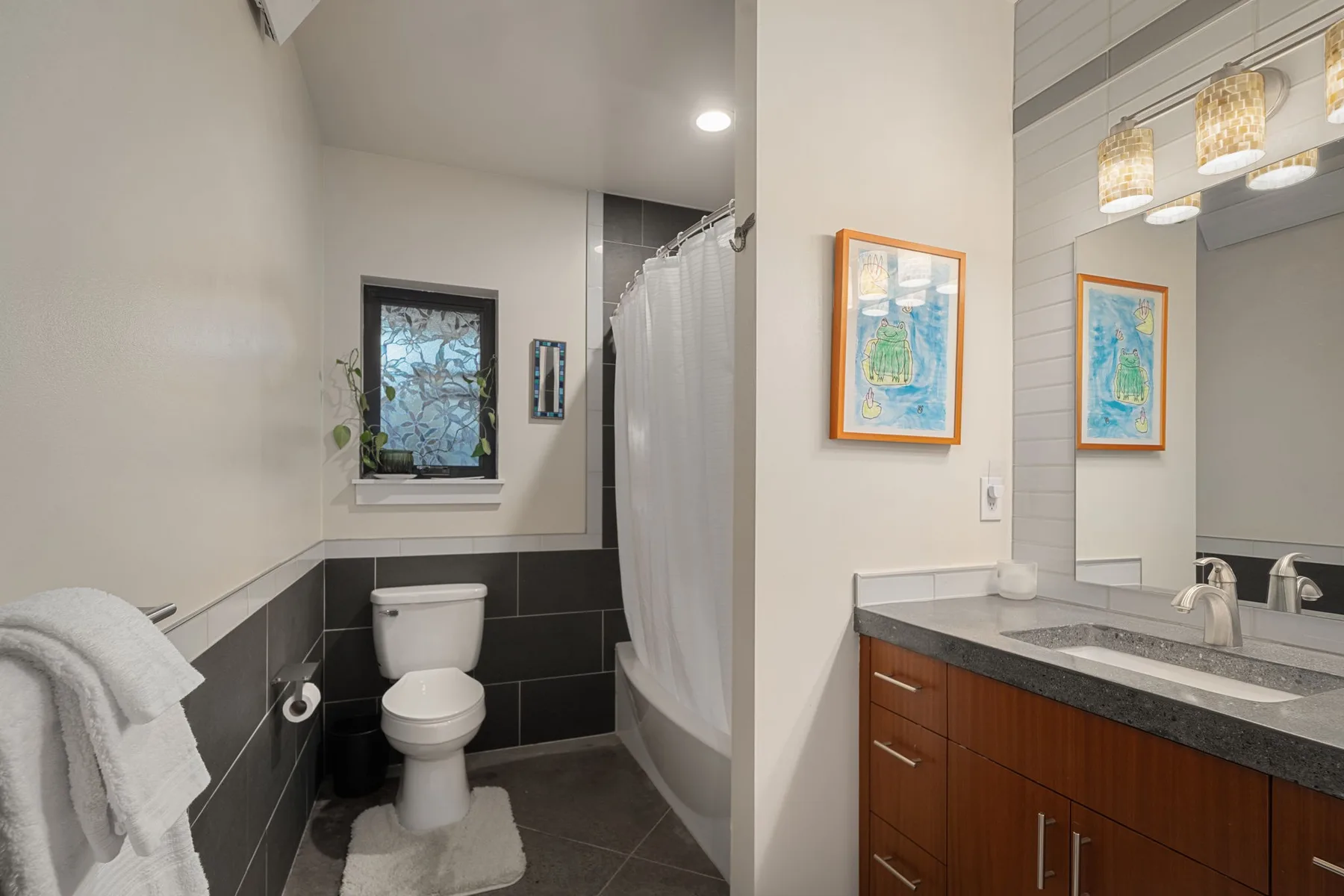 Un baño con inodoro, bañera y lavabo con mueble.