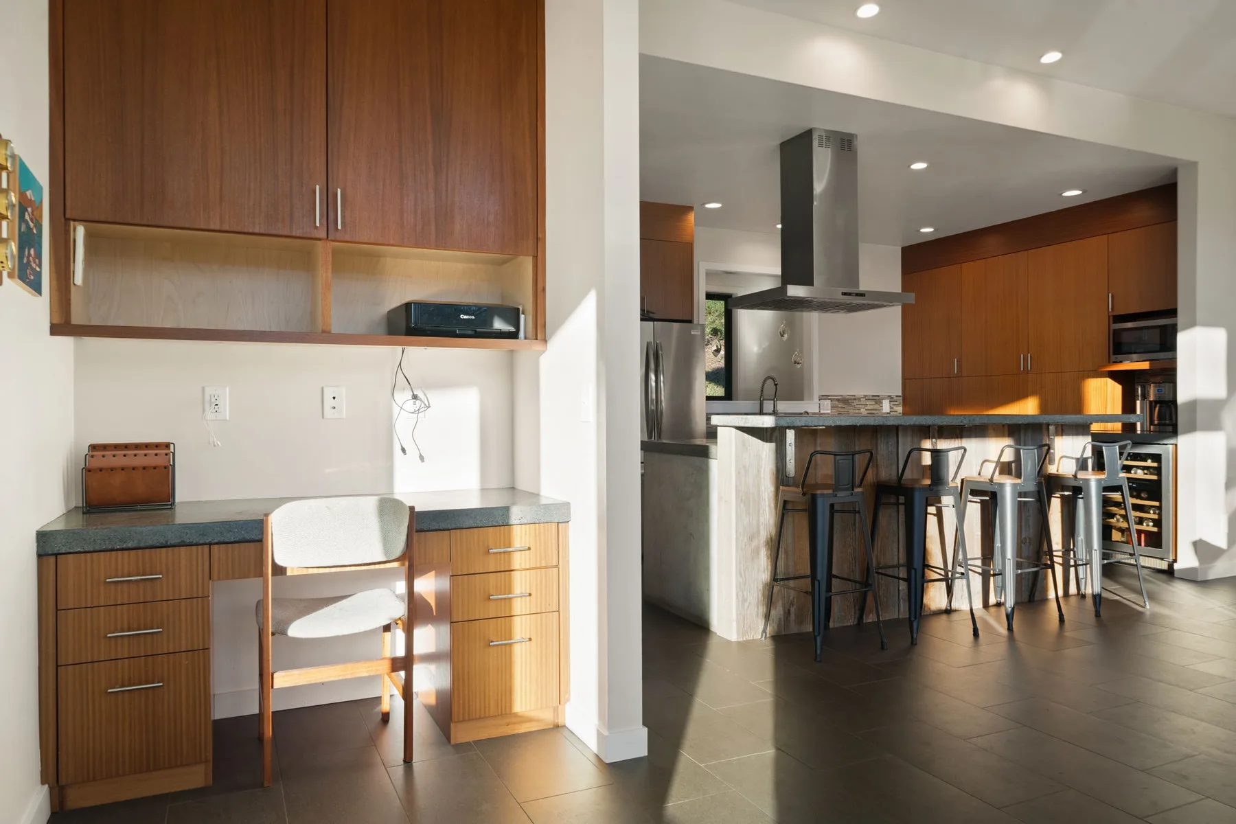 Una cocina moderna con barra de desayuno y una pequeña zona de escritorio.