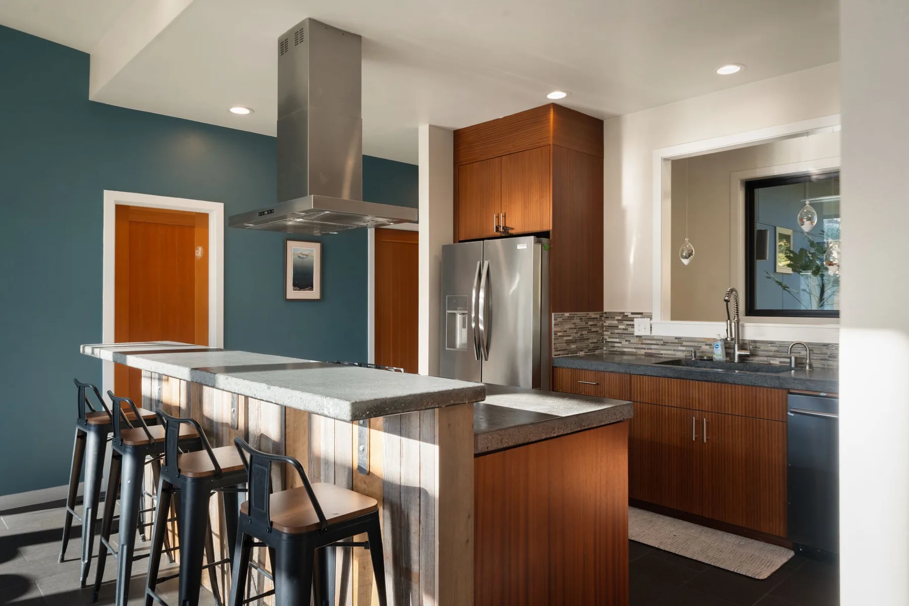 Una cocina moderna con una isla central y electrodomésticos de acero inoxidable.