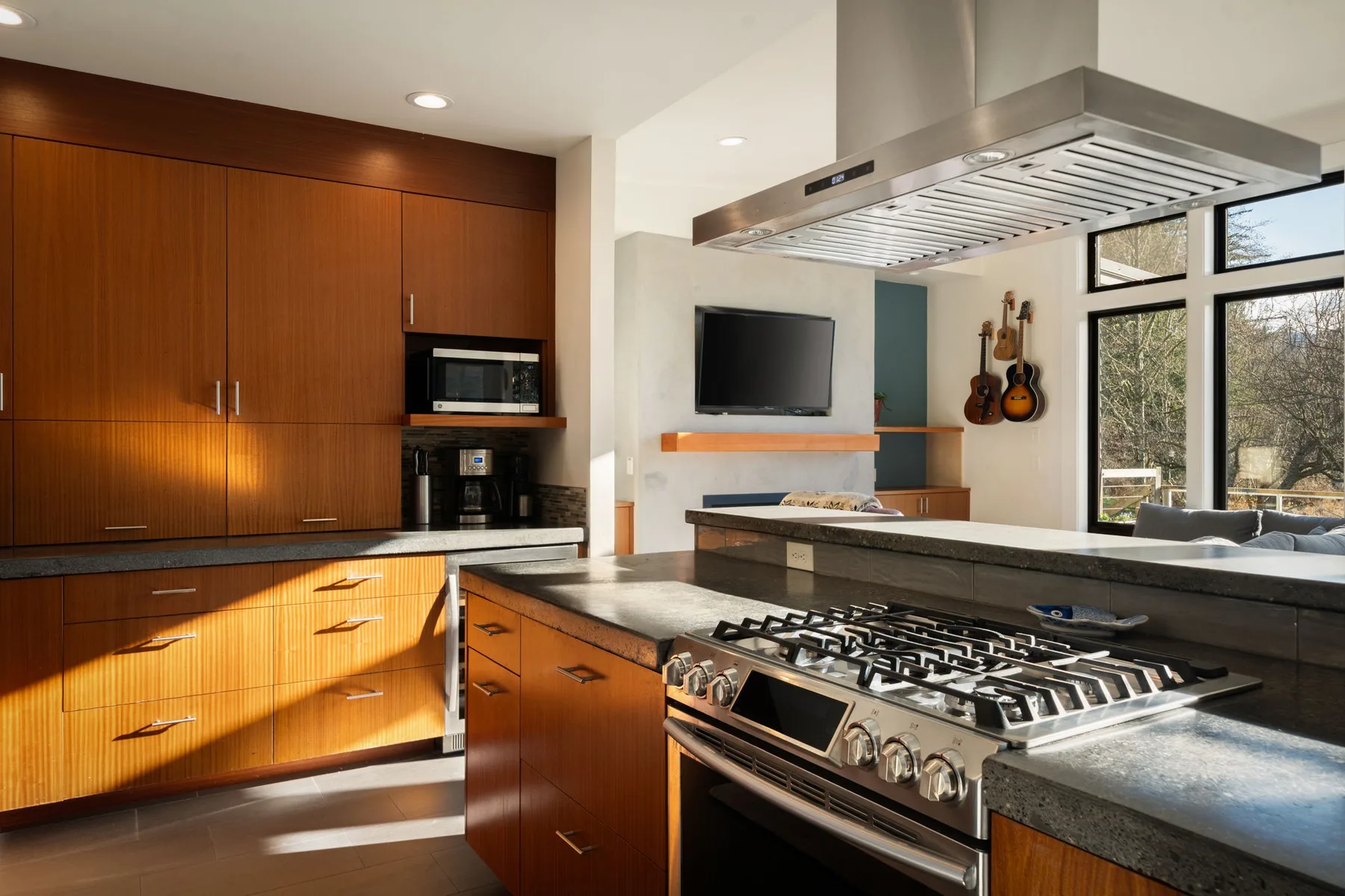 Una cocina moderna con gabinetes de madera, una isla central y una estufa de acero inoxidable.