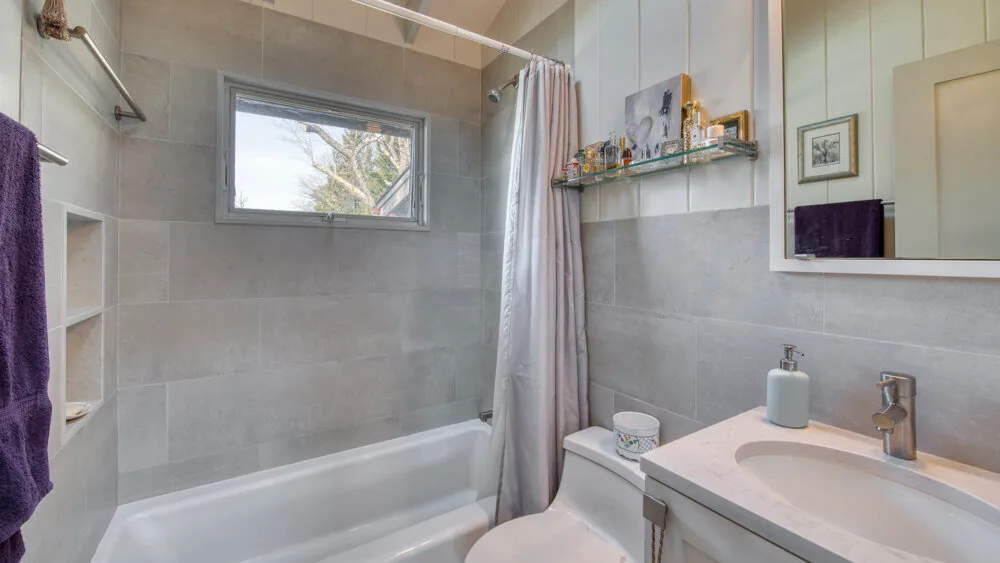 Un baño con bañera, cortina de ducha y lavabo.