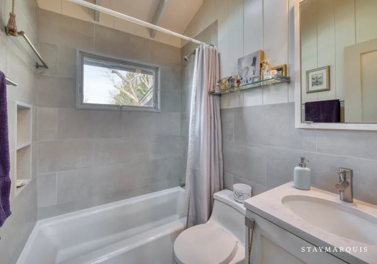 Un baño con bañera, cortina de ducha y lavabo.