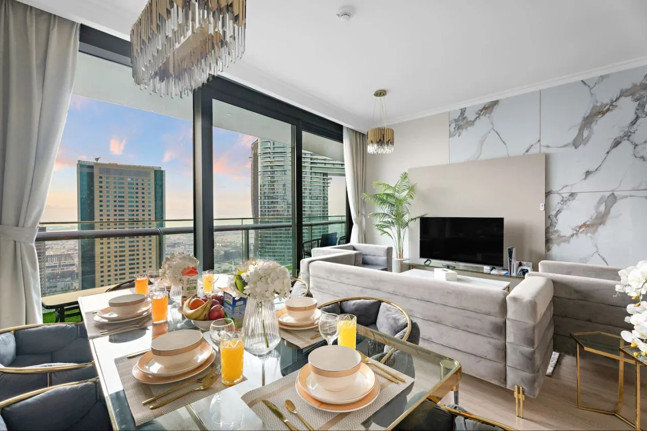 A living and dining area with a set table and large windows.