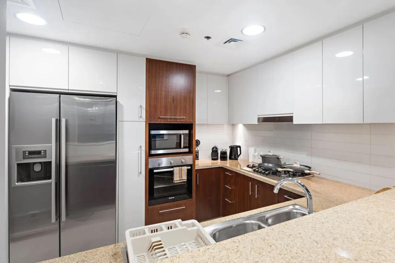 A modern kitchen with stainless steel appliances and a sink.
