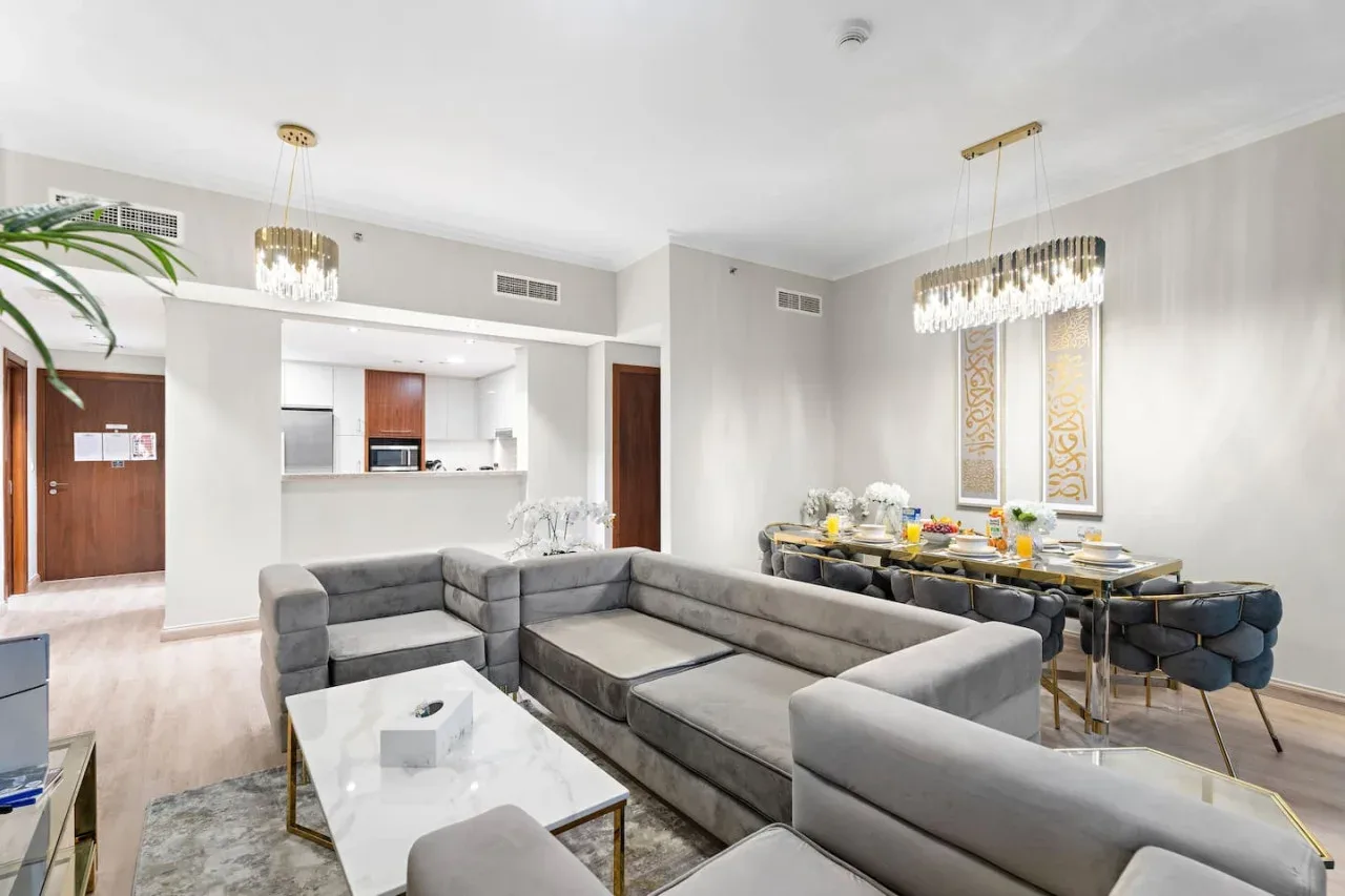 A spacious living and dining area with gray seating and a dining table.