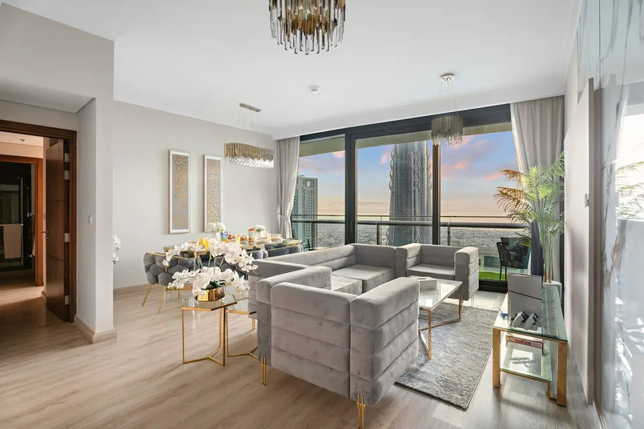 A bright living room features seating around a coffee table beside expansive windows.