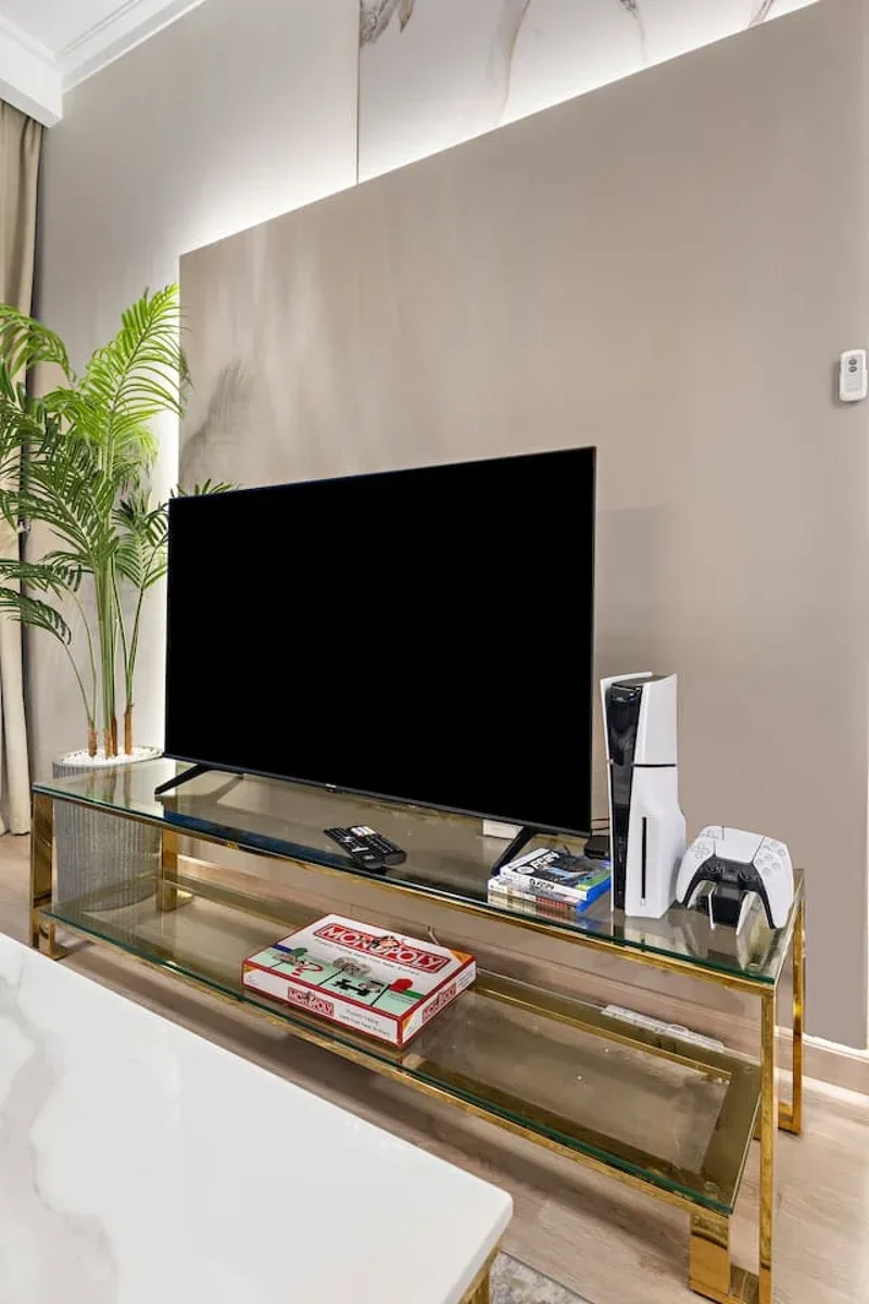 A living room entertainment area with a television on a glass console.