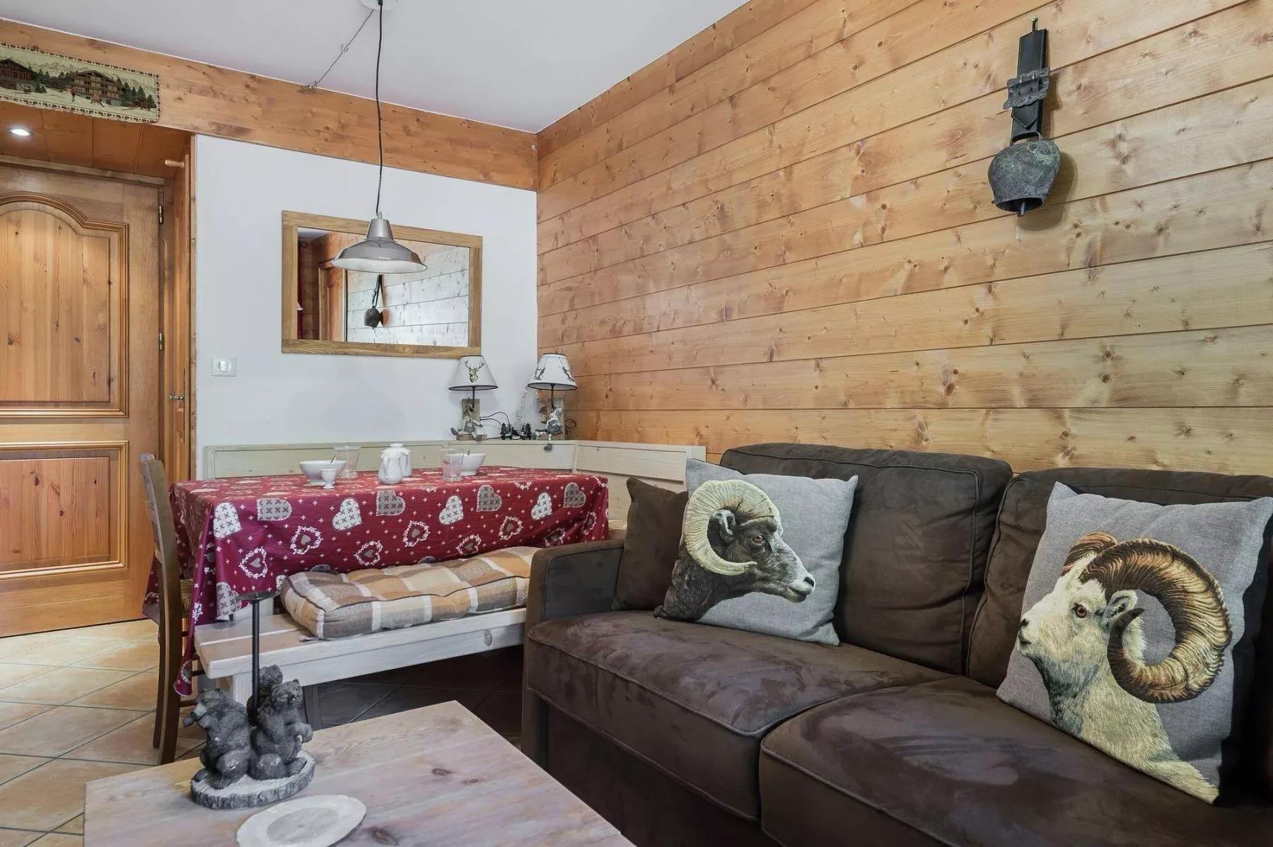 A rustic living area with a brown sofa and a small dining table.
