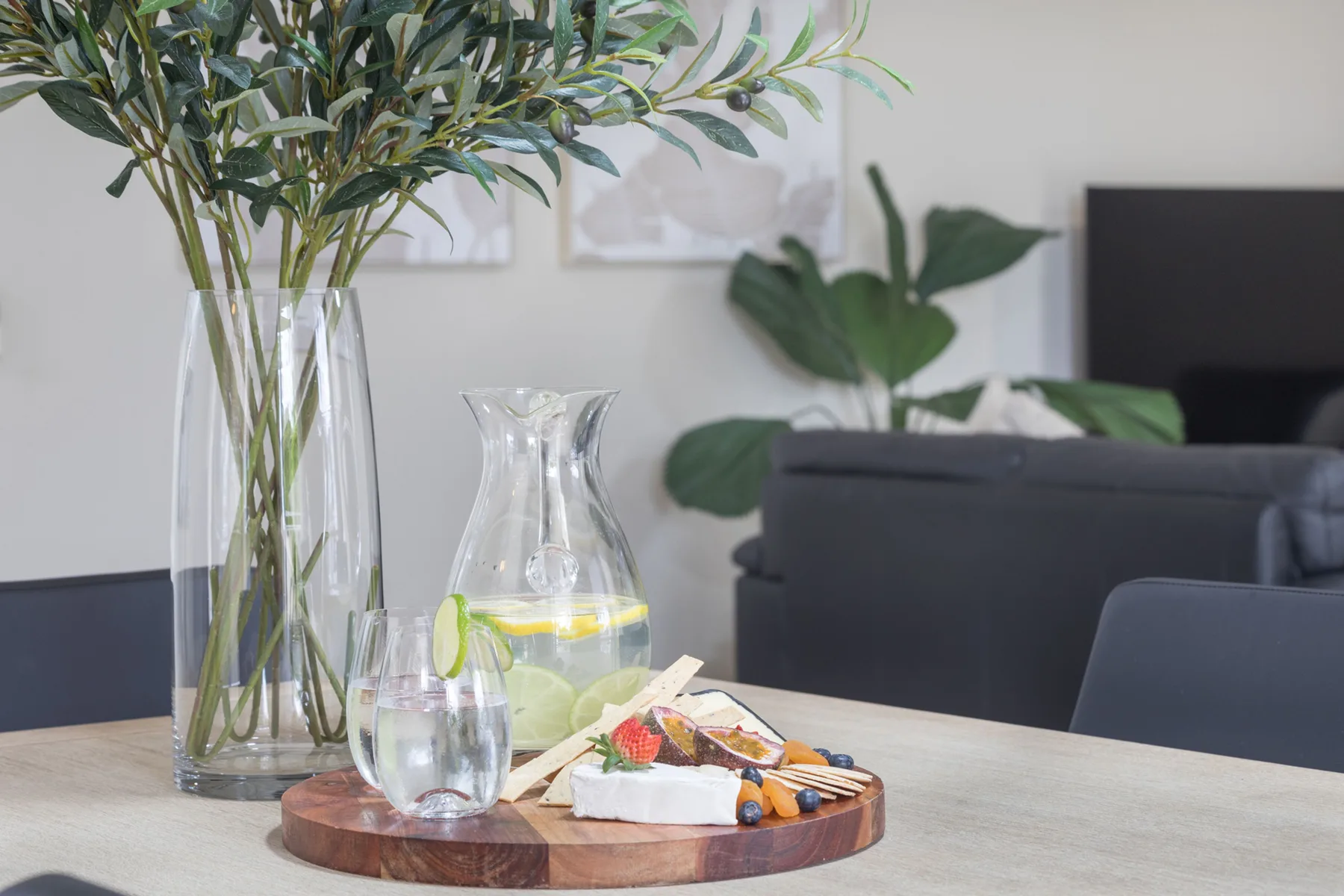 Una zona de estar con una mesa que tiene una bebida y aperitivos.