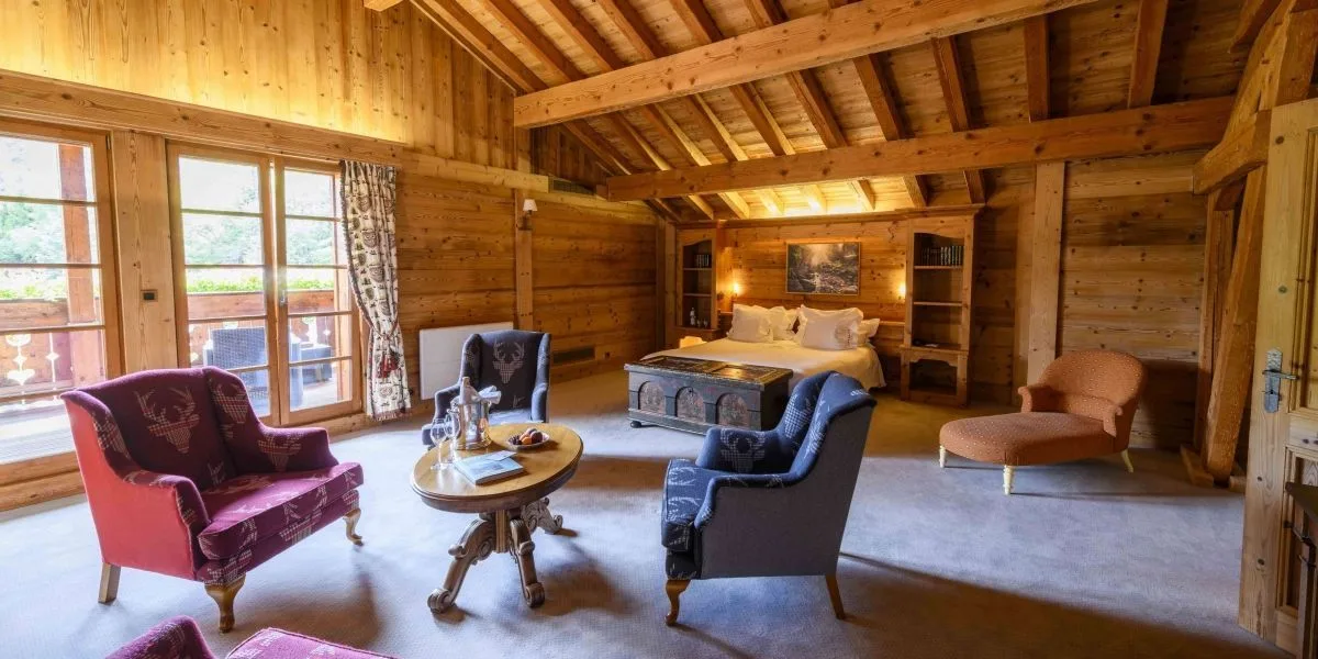 Suite de estilo chalet con vigas vistas, zona de estar, terraza y baño