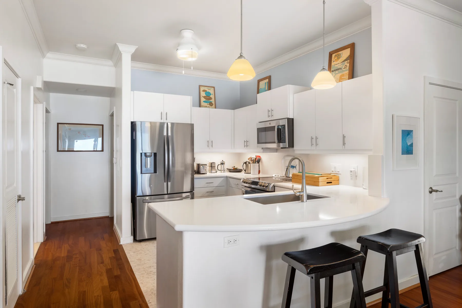 A bright kitchen with white cabinets, stainless steel appliances, and a central island.