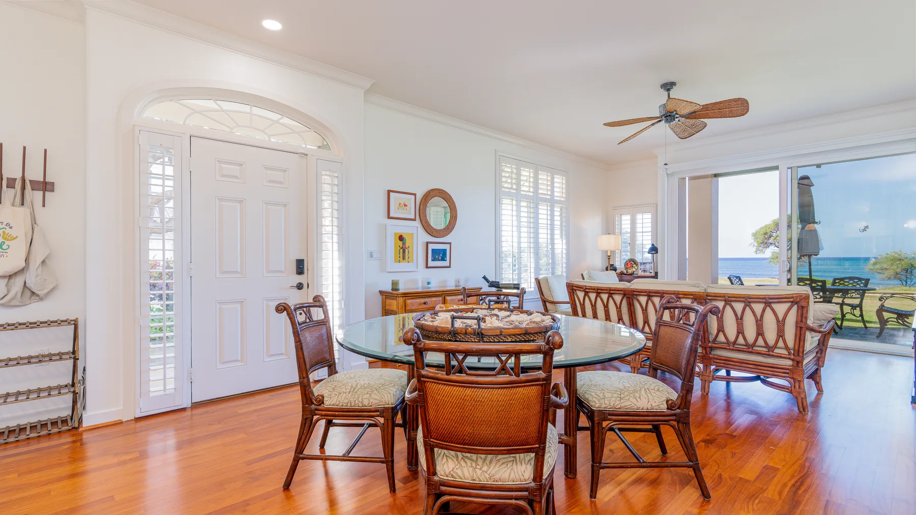 A bright dining area with a glass table and sliding doors opening onto a patio.
