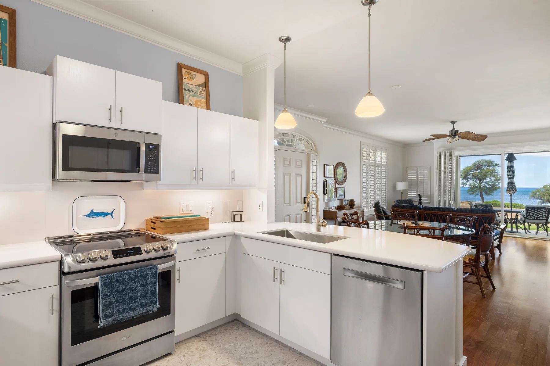 A bright kitchen with white cabinets, a central island, and an adjoining dining area.