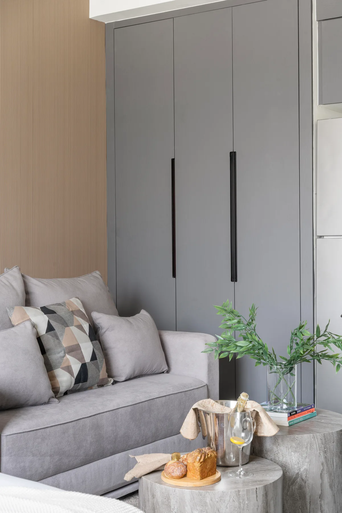 Una sala de estar con un sofá gris, cojines estampados y una mesa baja redonda.