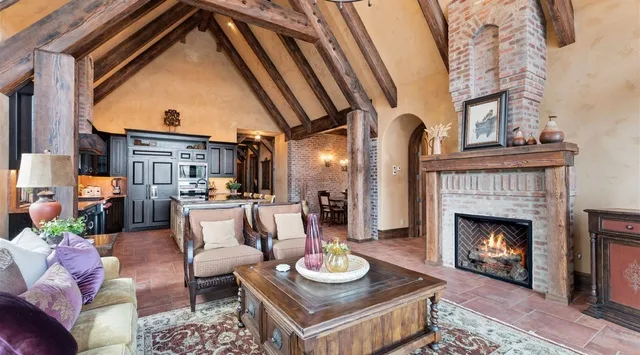 Una sala rústica con chimenea, asientos y una cocina abierta.