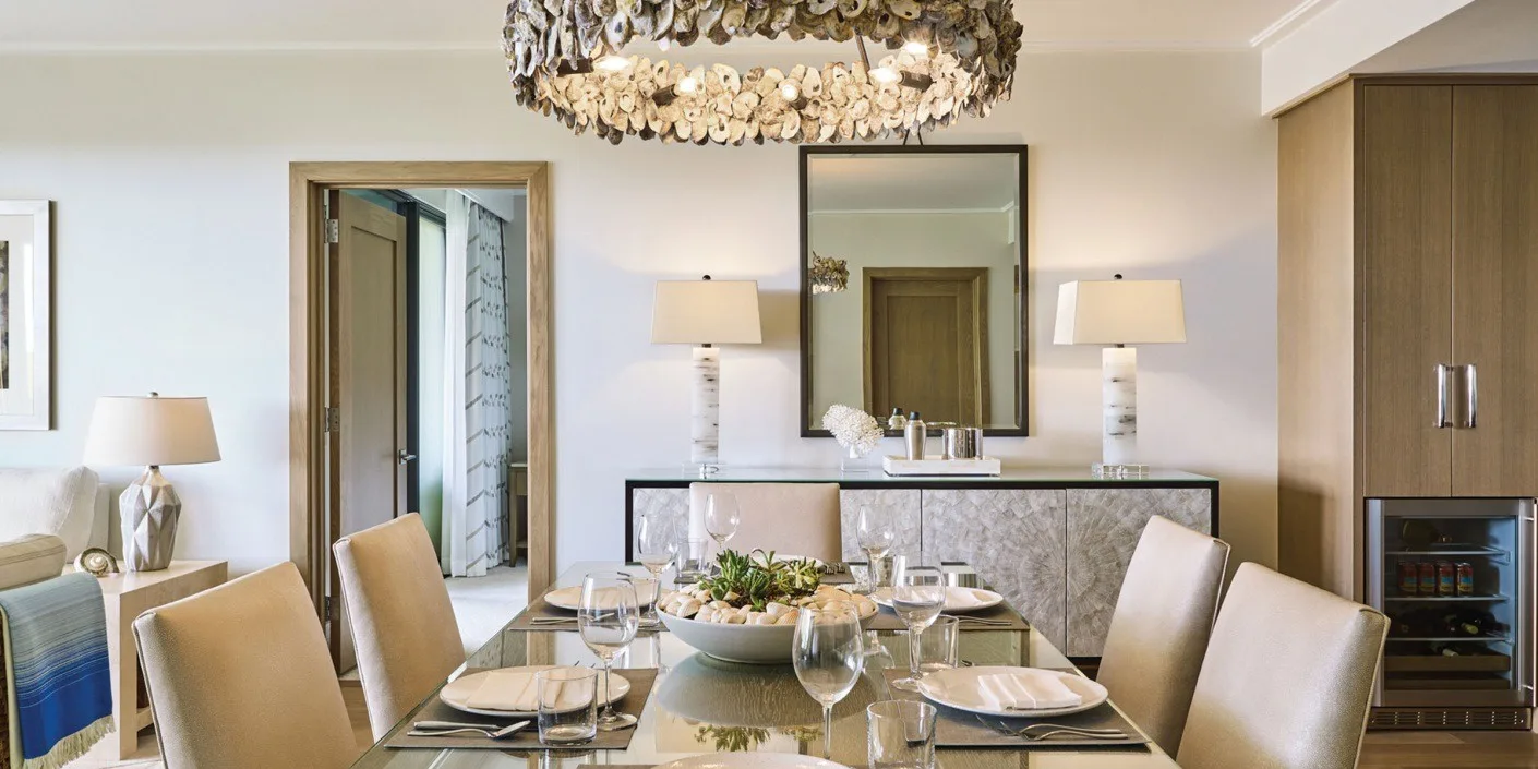 Comedor con la mesa puesta, sillas y una lámpara de araña.
