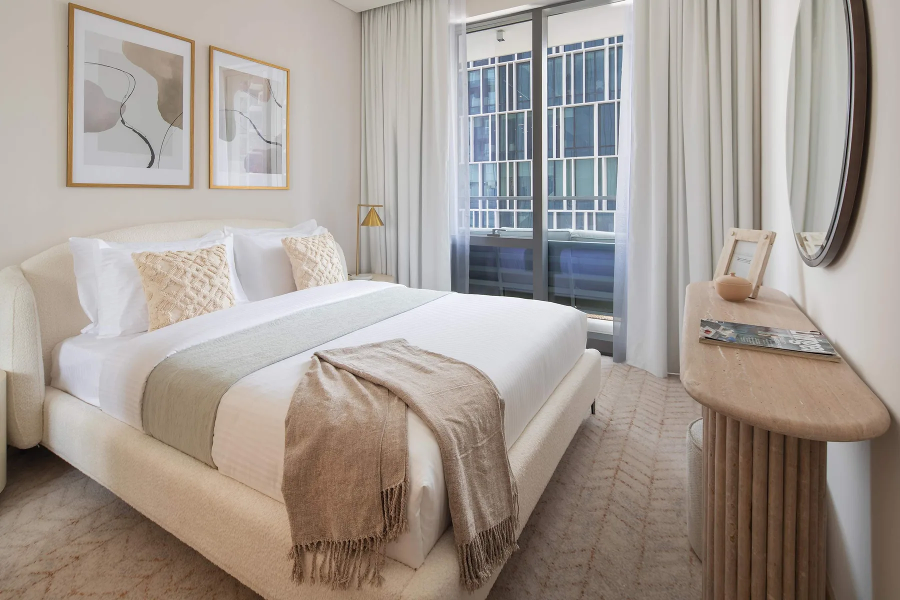 Un dormitorio luminoso con una cama bien arreglada y ventanas altas.