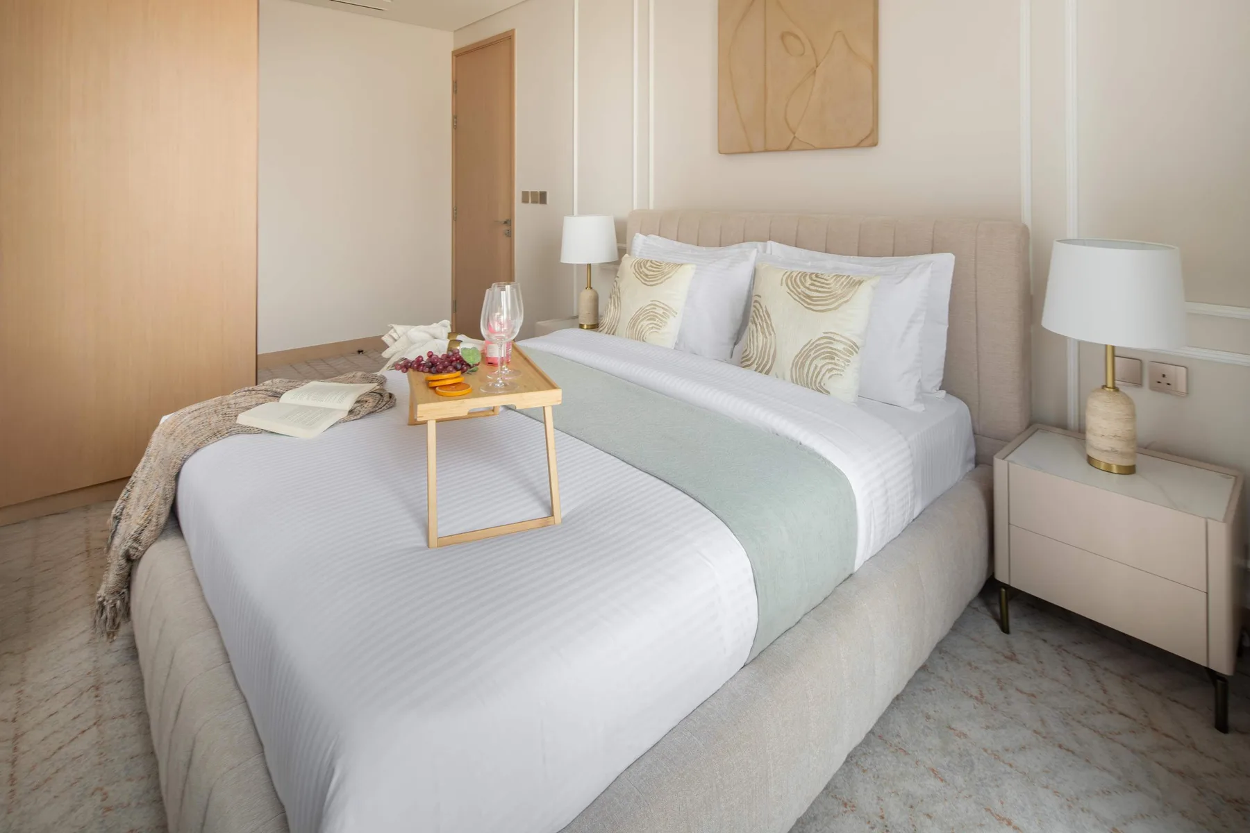 Un dormitorio con una cama bien tendida y mesitas de noche.
