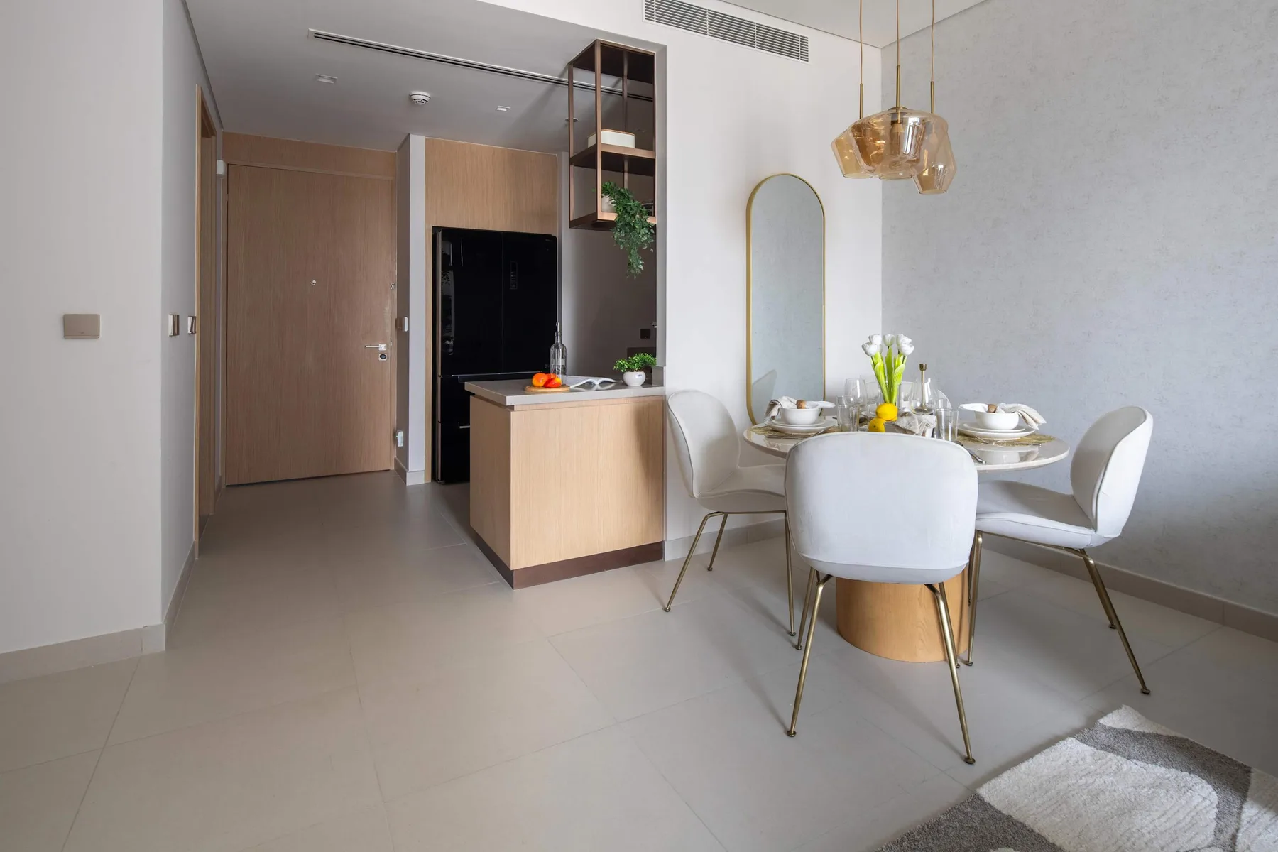 Un comedor con la mesa puesta y una encimera de cocina al fondo.