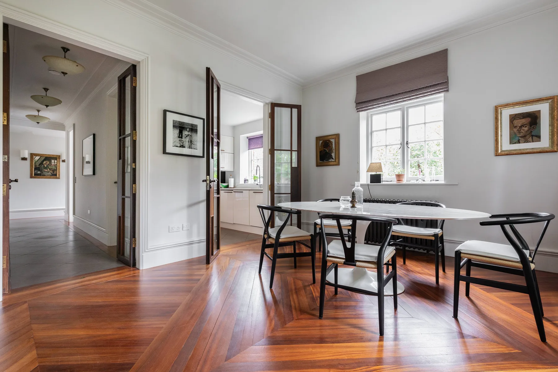 Un comedor con una mesa larga y sillas junto a una ventana grande.