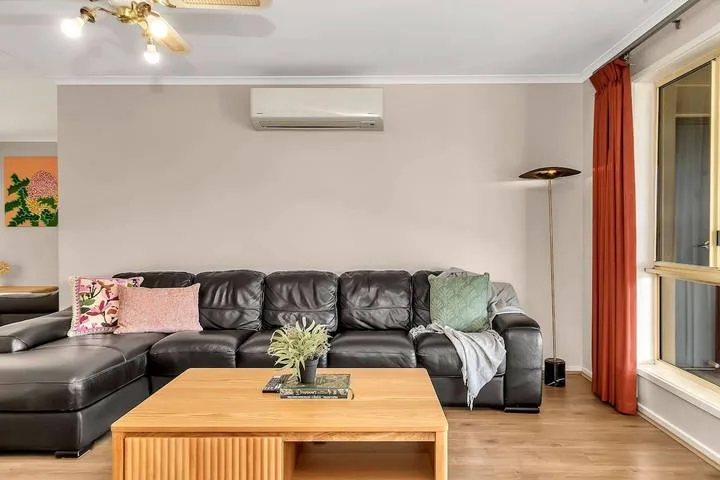 Sala de estar con asientos seccionales oscuros y una mesa de centro de madera.